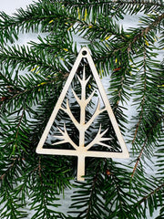 Decorative triangle ornament with tree branch design on a green pine branch background