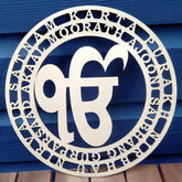 Decorative metal sign with circular design and text on a blue wooden background