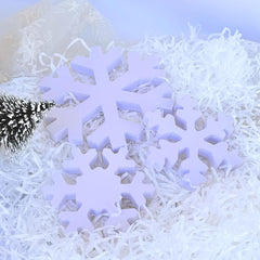 White snowflake-shaped objects on a white textured surface