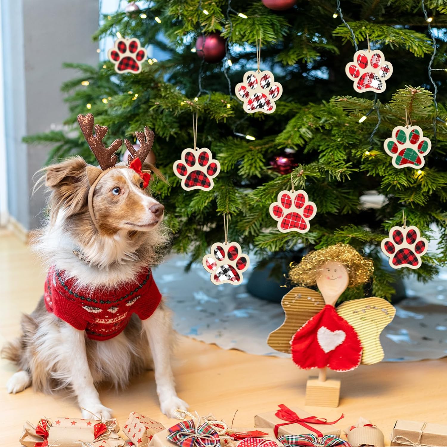 Dog wearing a red sweater with Christmas decorations and a tree in the background