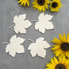White paper leaves on a gray surface with yellow sunflowers.