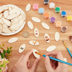 Crafting activity with wooden shapes, paint containers, and a hand painting a small object on a wooden table.