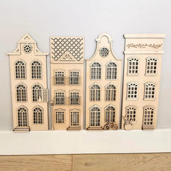 Set of four wooden model houses on a light gray background