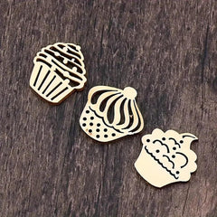 Three wooden cupcake-shaped stamps on a wooden surface
