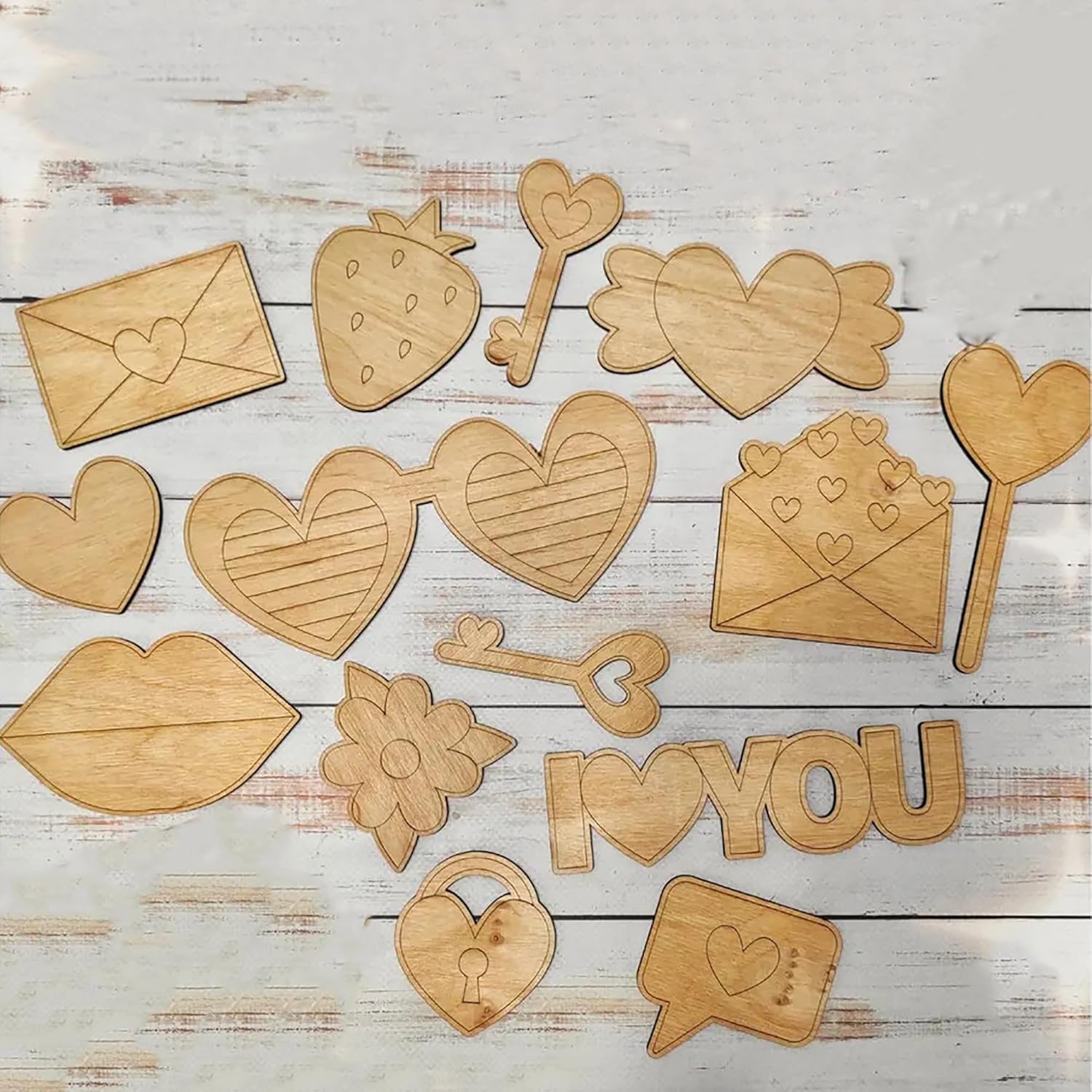 Wooden cutouts of hearts, keys, envelopes, and 'I LOVE YOU' letters on a wooden surface.