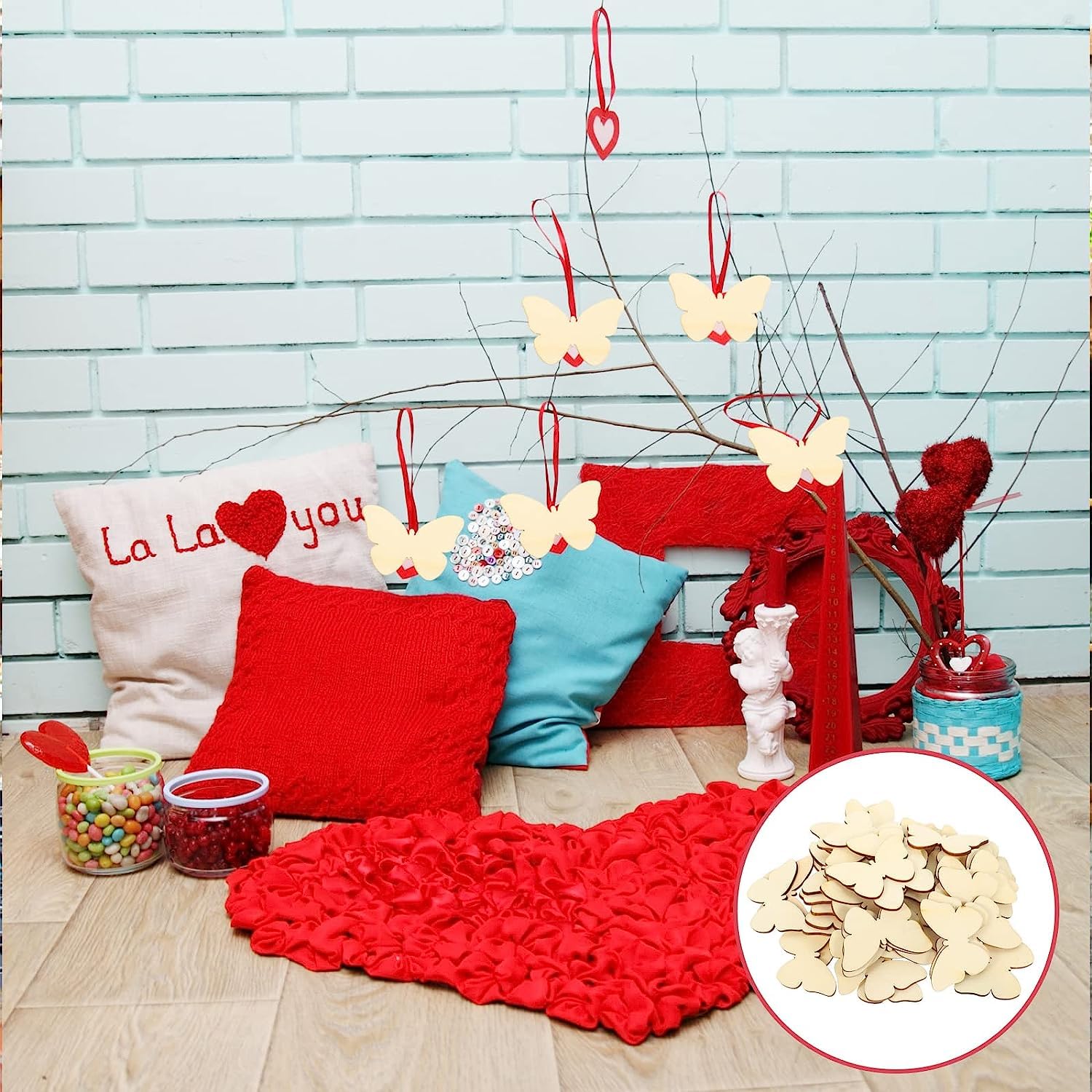 Decorative setup with pillows, a red blanket, and butterfly decorations against a light blue brick wall.