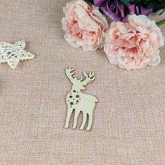 Wooden deer ornament on a textured surface with pink flowers