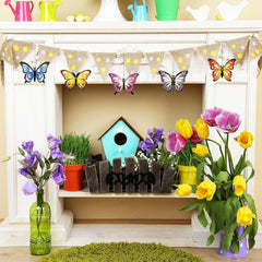 Decorative shelf with flowers, a birdhouse, and butterfly decorations on a fireplace mantle.