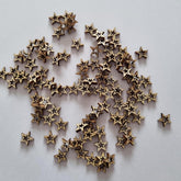 Bronze star-shaped objects scattered on a light gray background