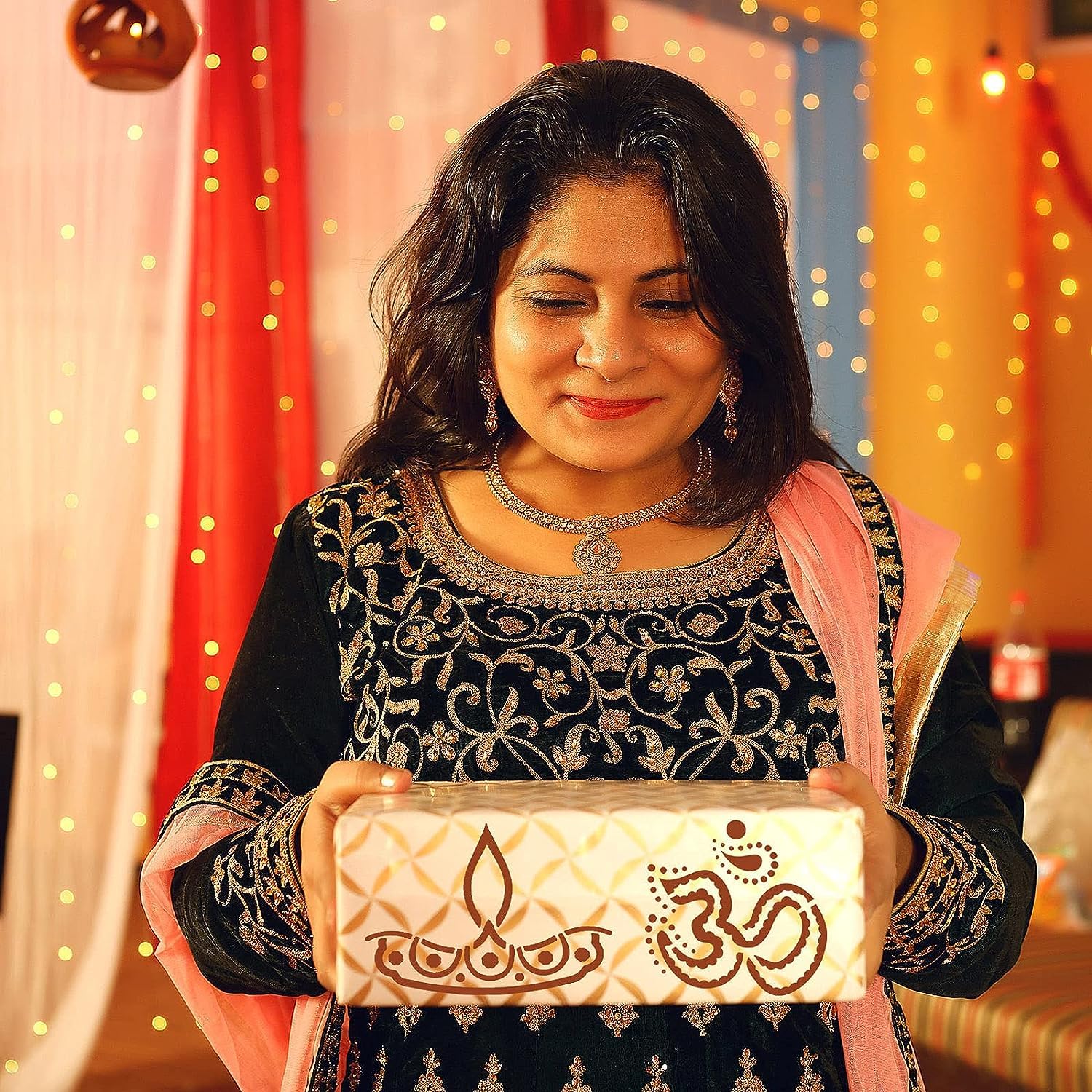Woman holding a decorative box with intricate designs against a colorful background