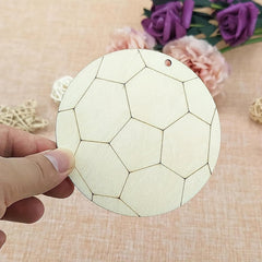 Hand holding a round wooden coaster with geometric pattern on a textured surface with flowers in the background