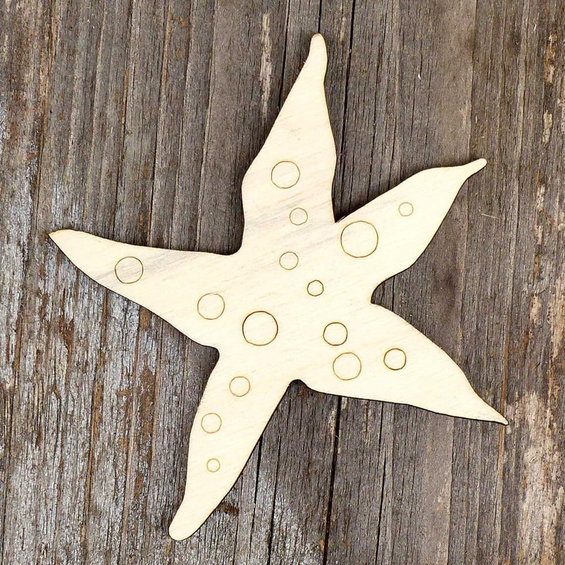 Star-shaped wooden cutout with circular holes on a wooden surface