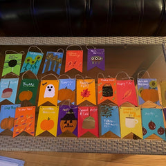 Set of colorful Halloween-themed paper bags on a woven surface.