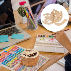 Wooden geometric shapes on a desk with art supplies and a laptop.