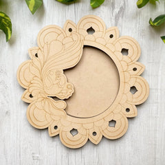 Decorative wooden frame with intricate cut-out patterns on a light wooden surface.
