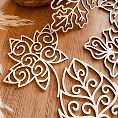 Decorative wooden cutouts with intricate patterns on a wooden surface