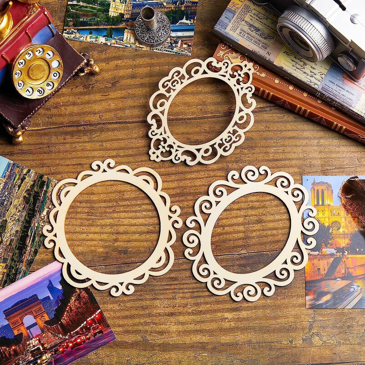 Three decorative wooden frames on a wooden surface with travel-themed items.
