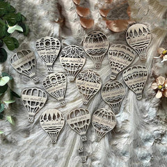 Wooden hot air balloon-shaped milestones with milestone numbers on a textured surface.