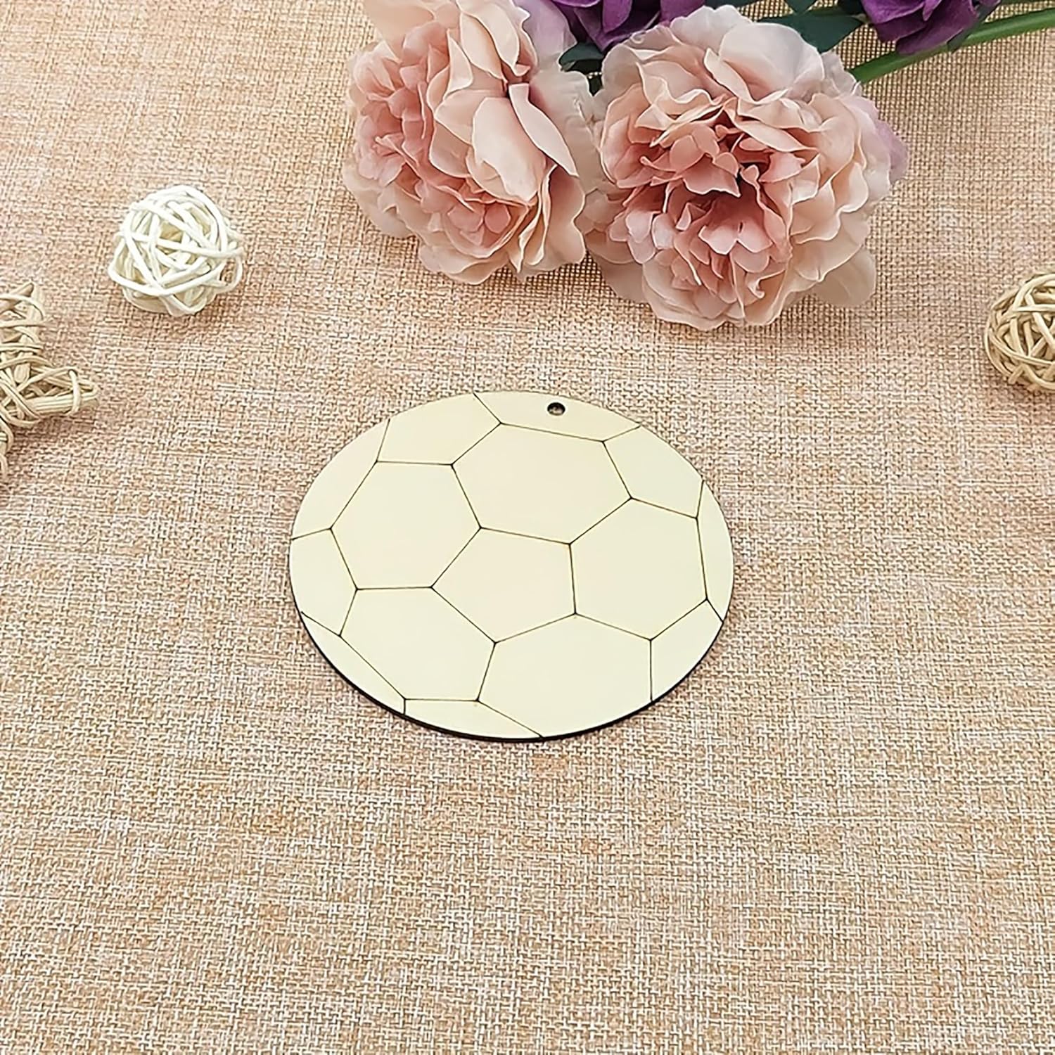Decorative round mirror with geometric pattern on a textured beige surface with flowers and decorative elements.