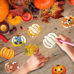 Children's hands coloring pumpkin-shaped stickers on a wooden table with pumpkins and leaves.