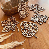 Decorative wooden leaf shapes on a wooden surface with a basket in the background.