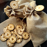Wooden tags with heart designs and text on a burlap bag
