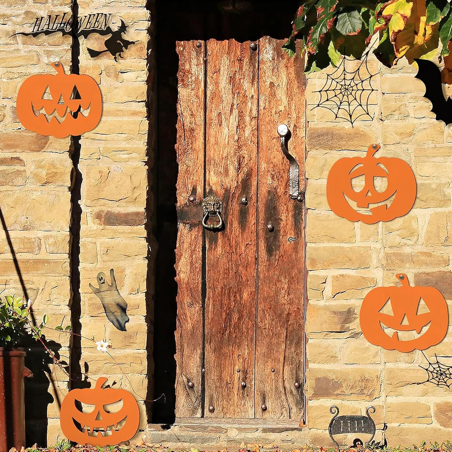 Decorative Halloween scene with pumpkins, cobwebs, and a wooden door on a stone wall.