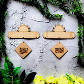 Wooden nameplates with engraved names on a textured surface with greenery around.