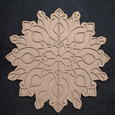 Decorative wooden snowflake cutout on a black background