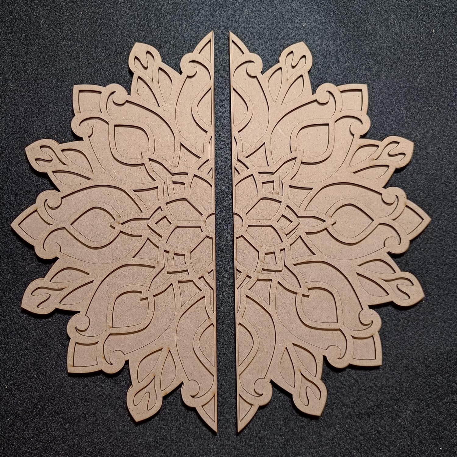 Two beige decorative snowflake shapes on a black background