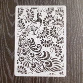 Decorative stencil with peacock design on a wooden surface