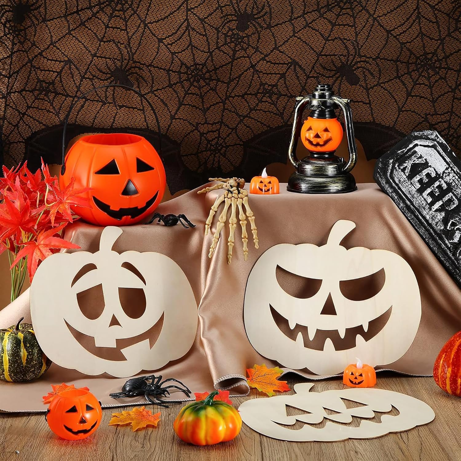 Halloween-themed table setting with pumpkins, lanterns, and decorations against a spider web backdrop.