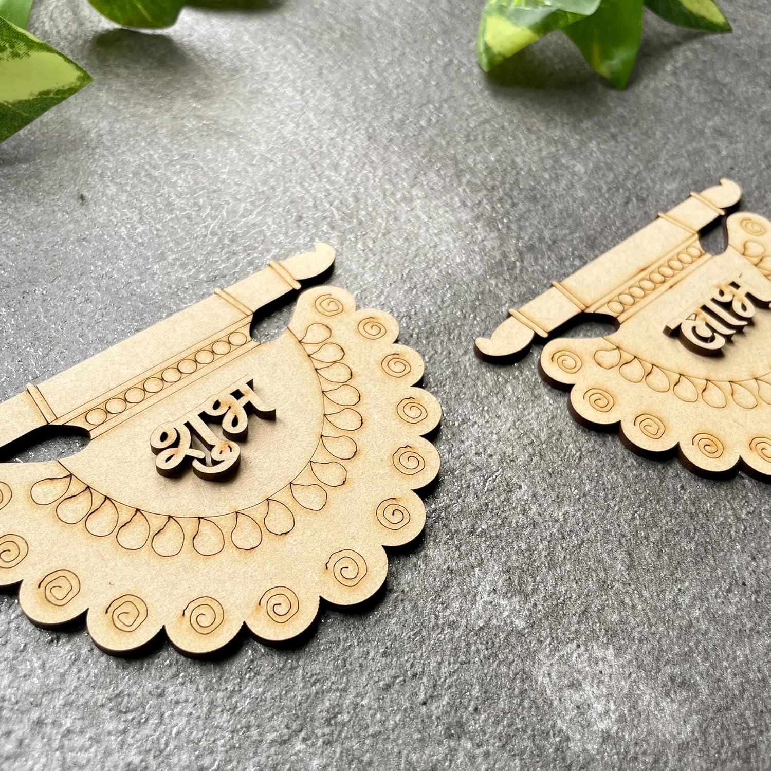 Two wooden decorative items with intricate patterns on a gray surface.