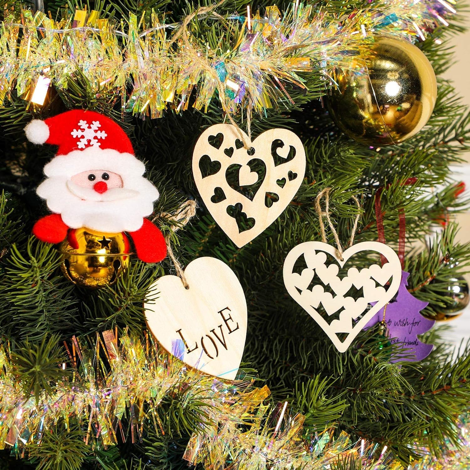 Decorative Christmas ornaments on a tree with tinsel and lights.