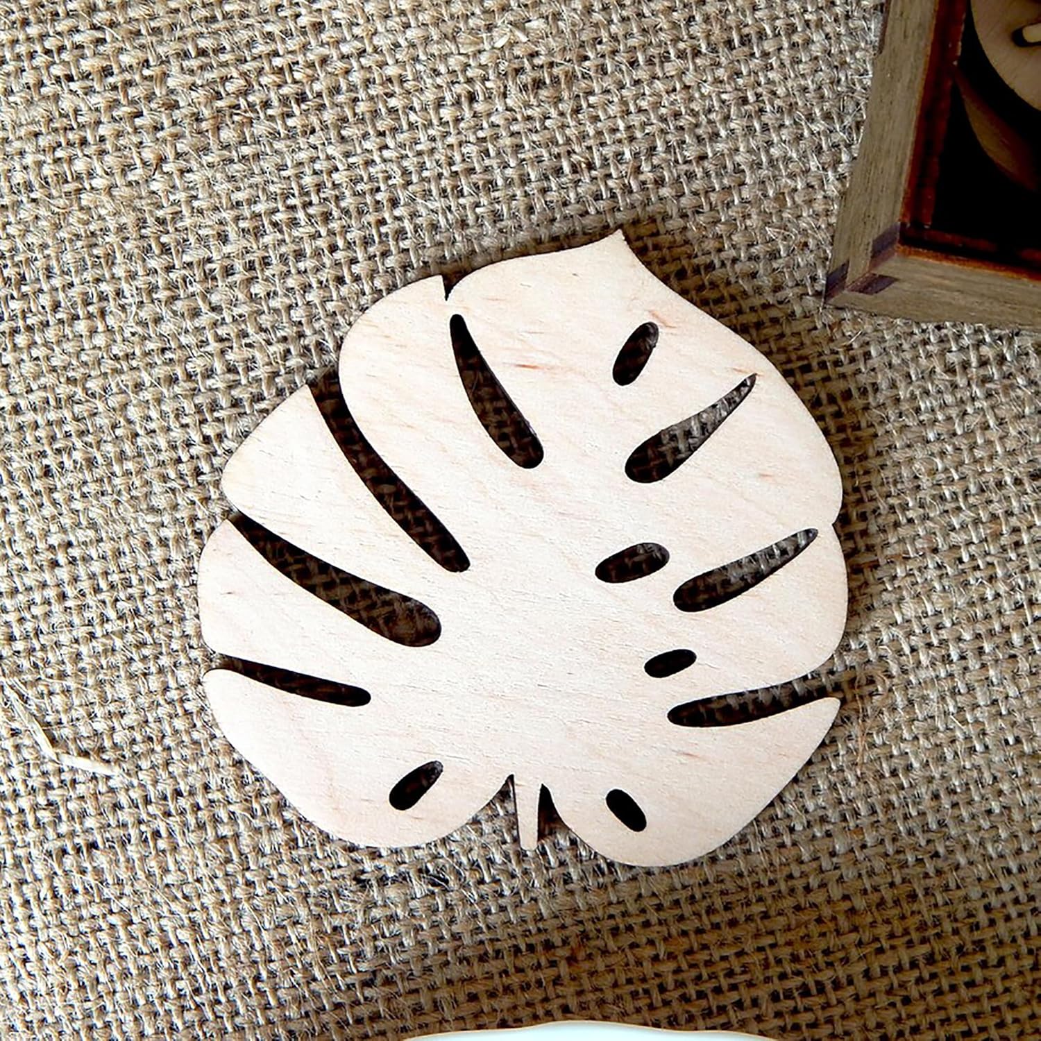 Decorative leaf-shaped coaster on a textured surface