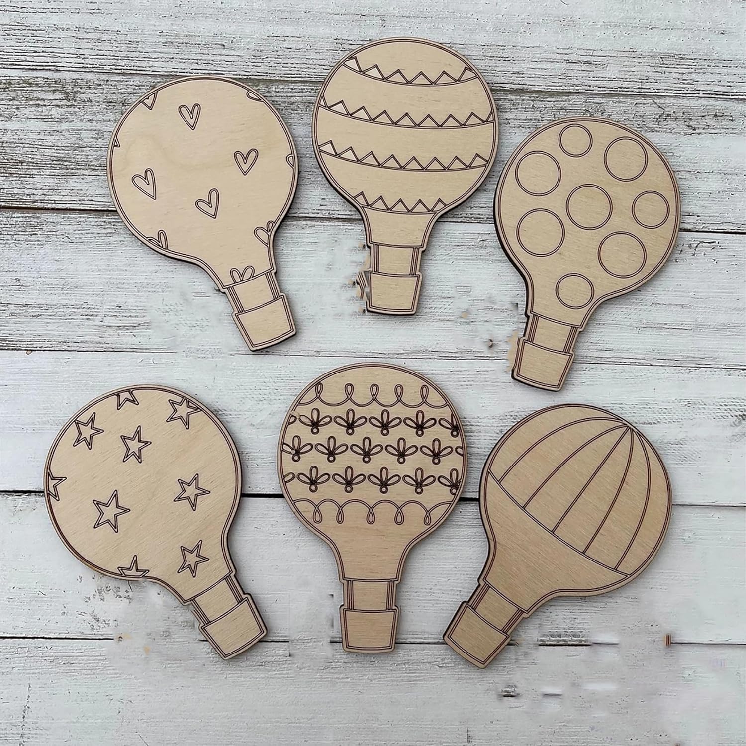 Set of six cardboard hot air balloon shapes on a wooden surface