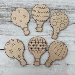 Set of six cardboard hot air balloon shapes on a wooden surface