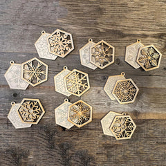 Decorative hexagonal pendants with snowflake designs on a wooden surface