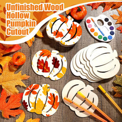 Unfinished wood pumpkin cutouts with fall leaves, paint palette, and brushes on a wooden surface.