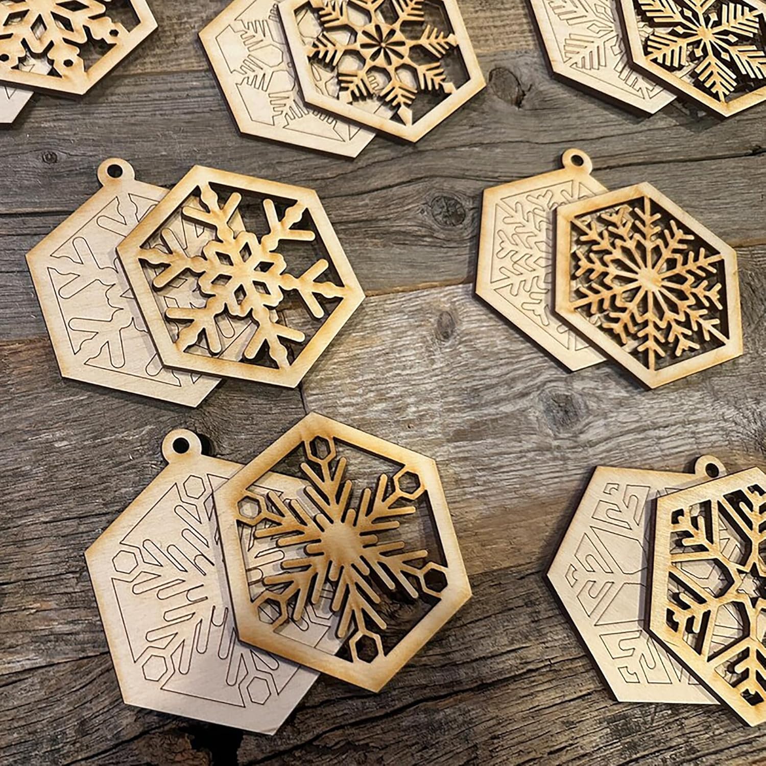 Hexagonal wooden ornaments with snowflake designs on a wooden surface