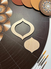 Decorative wooden cutout on a textured surface with paintbrushes and color swatches.