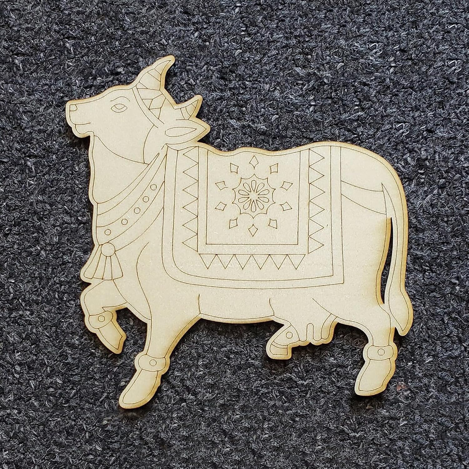 Decorative wooden bull figure with intricate patterns on a dark textured background