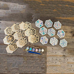 Decorative hexagonal stencils with paint and brushes on a wooden surface