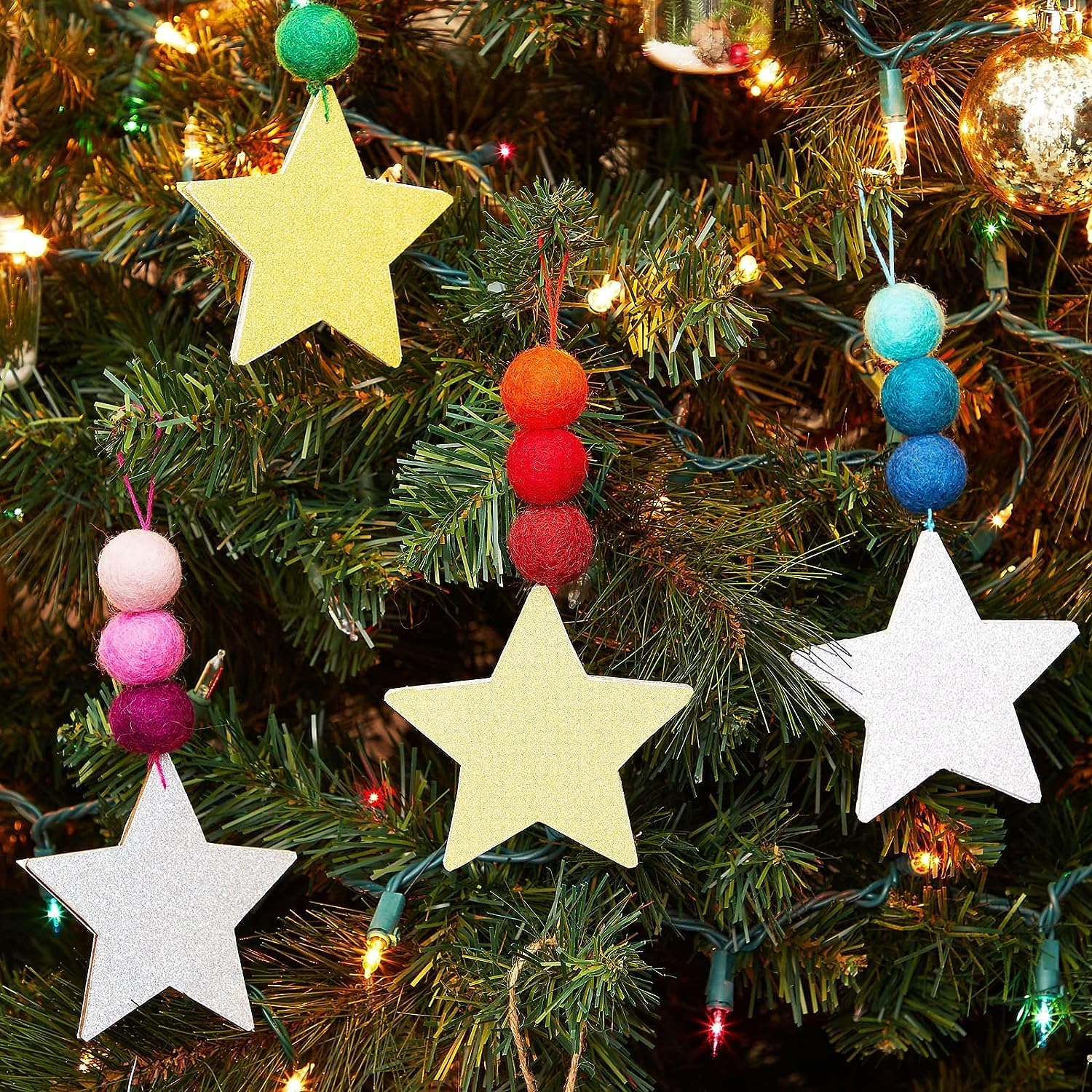 Colorful star and bead Christmas tree ornaments on a decorated tree.