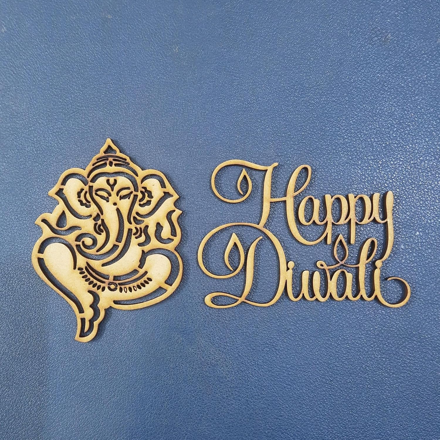 Decorative cutout of Ganesha and 'Happy Diwali' text on a blue background