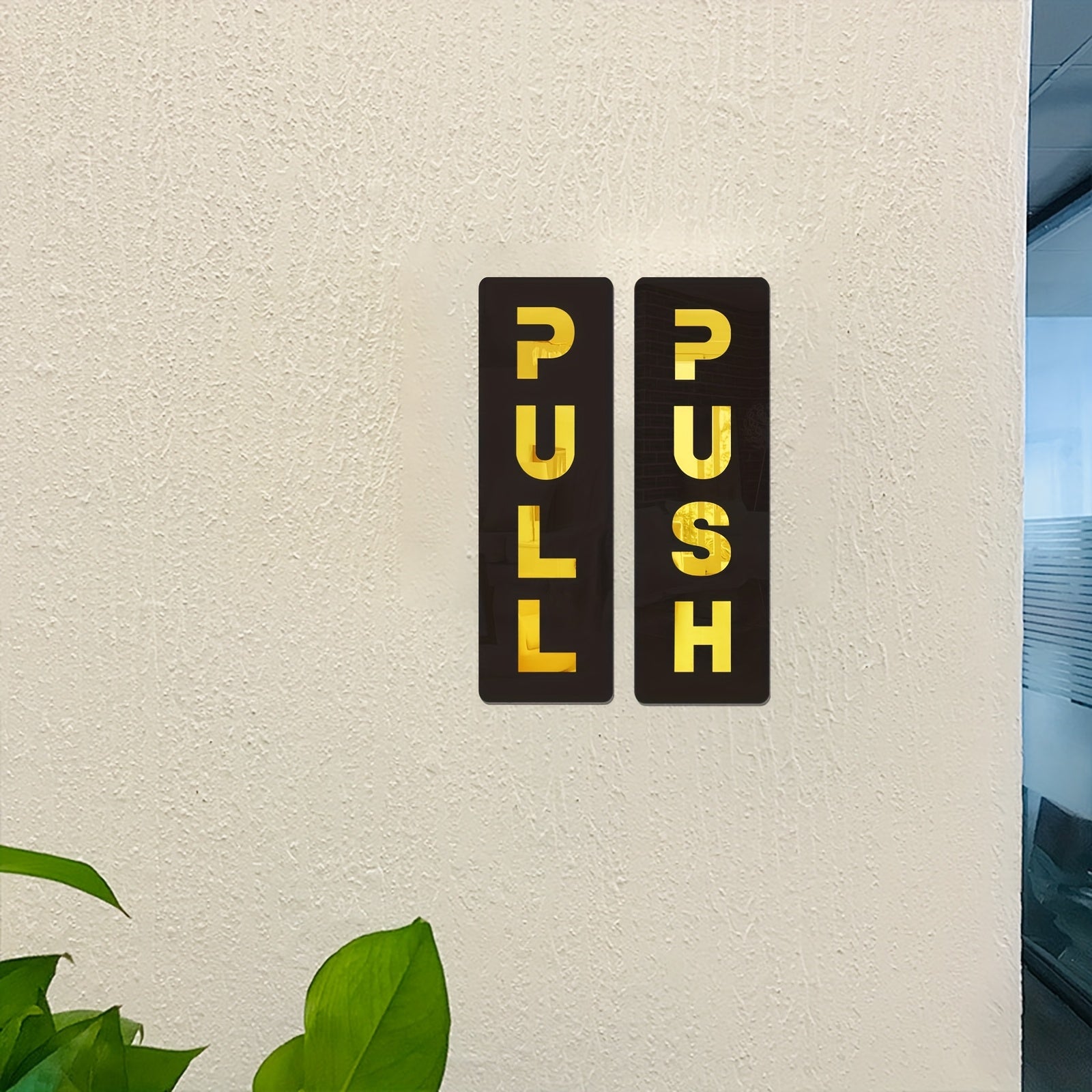 Two rectangular signs with 'PULL' and 'PUSH' text on a beige wall.