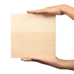 Hand holding a square piece of beige cardboard against a white background