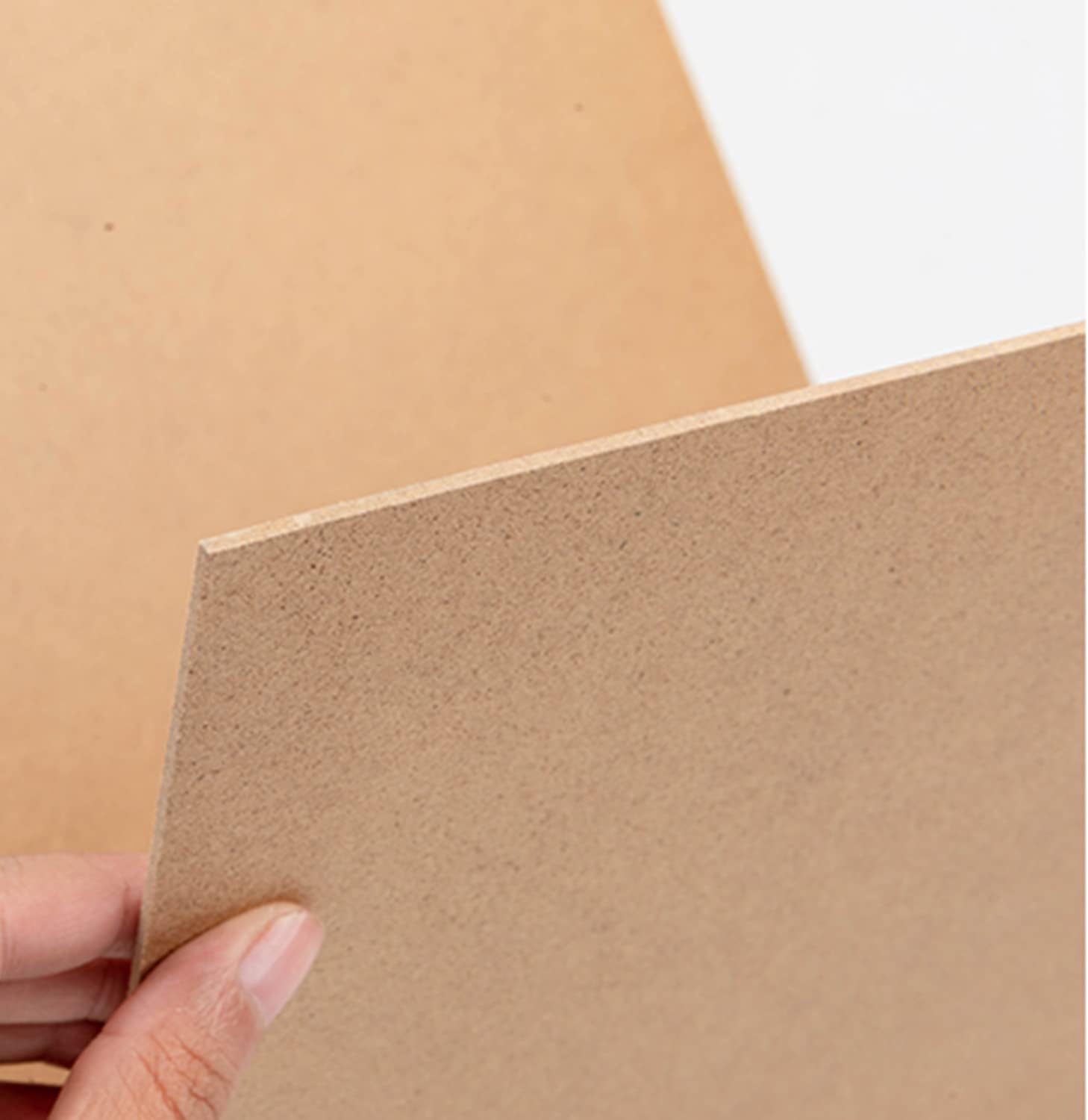 Brown cardboard sheet held by a hand with a plain background