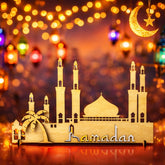 Decorative model of a mosque with 'Ramadan' text on a blurred festive background with lights.
