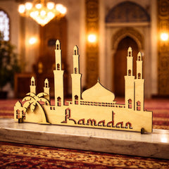 Decorative model of a mosque with 'Ramadan' on a marble surface in a mosque setting.